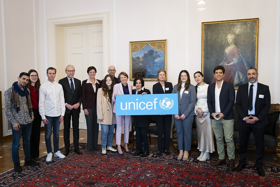 Elke Büdenbender hält das UNICEF-Banner inmitten einer Gruppe von am UNICEF-Neujahrsgespräch beteiligten Jugendlichen, Expertinnen und Experten sowie offiziellen Repräsentanten des Kinderhilfswerkes